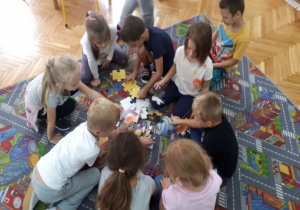 Dzieci układają puzzle o układzie słonecznym.